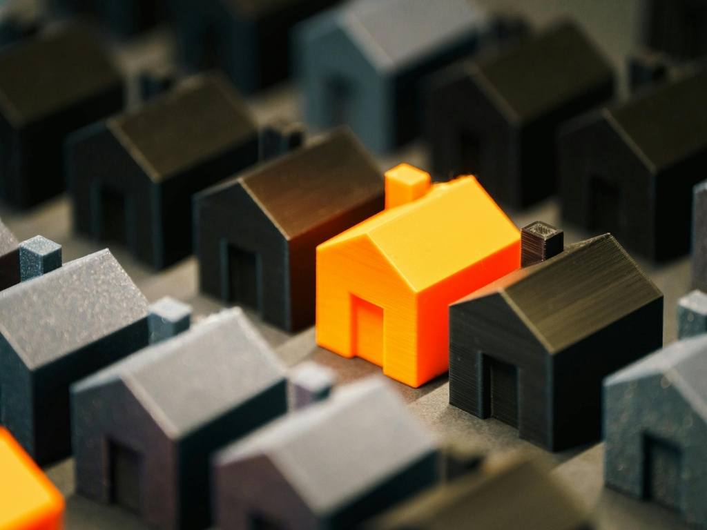 Model houses in rows with one house coloured orange